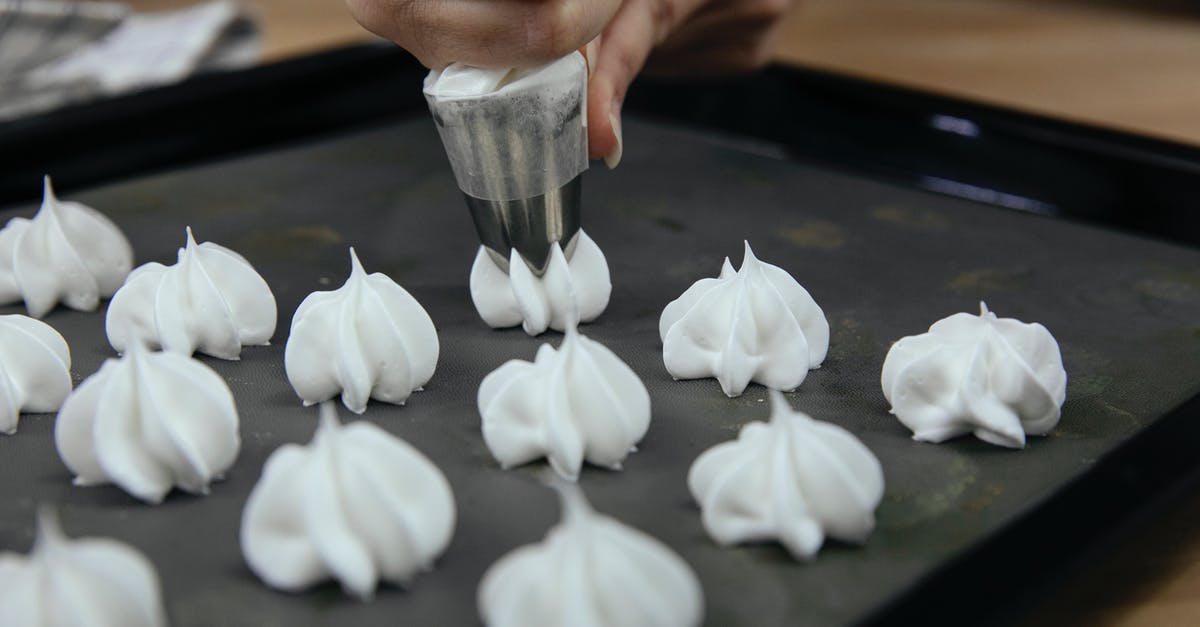 Egg temperature for meringue - Crop anonymous cook putting out meringue from pastry bag onto baking tray during cooking process Egg temperature for meringue - Crop anonymous cook putting out meringue from pastry bag onto baking tray during cooking process