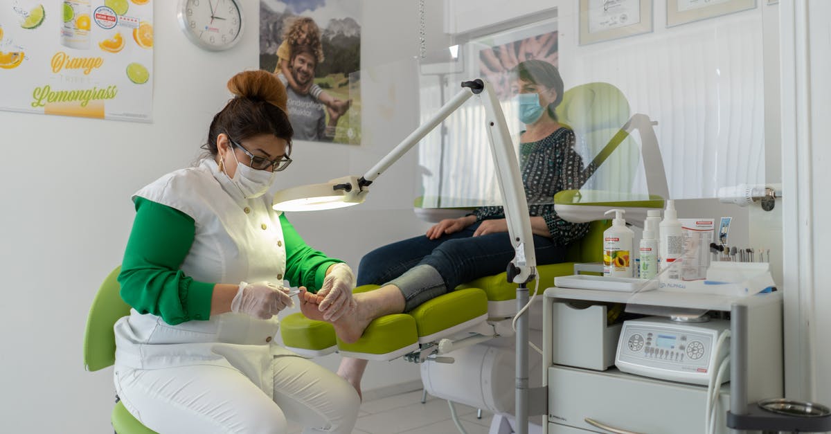 Ensuring dry-brined turkey process is safe - Concentrated professional beauty master in protective mask and gloves doing pedicure in modern salon Ensuring dry-brined turkey process is safe - Concentrated professional beauty master in protective mask and gloves doing pedicure in modern salon