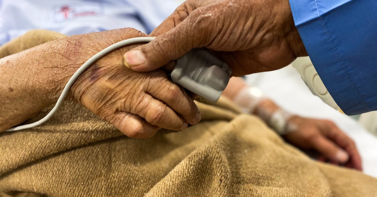 Extremely tender beef at hospital - Crop old female patient lying on medical bed with pulse oximeter on finger and old man holding wrinkled hand Extremely tender beef at hospital - Crop old female patient lying on medical bed with pulse oximeter on finger and old man holding wrinkled hand