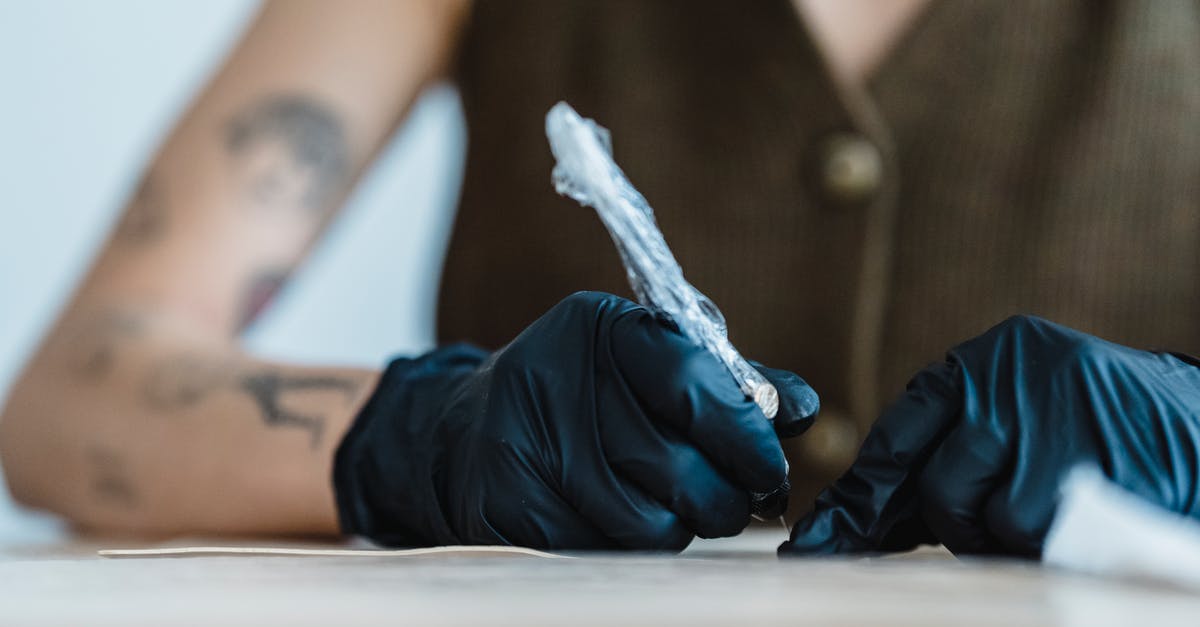 Fake poached salmon machine? - Crop anonymous artist in black gloves drawing with tattoo machine on practice skin on blurred background Fake poached salmon machine? - Crop anonymous artist in black gloves drawing with tattoo machine on practice skin on blurred background