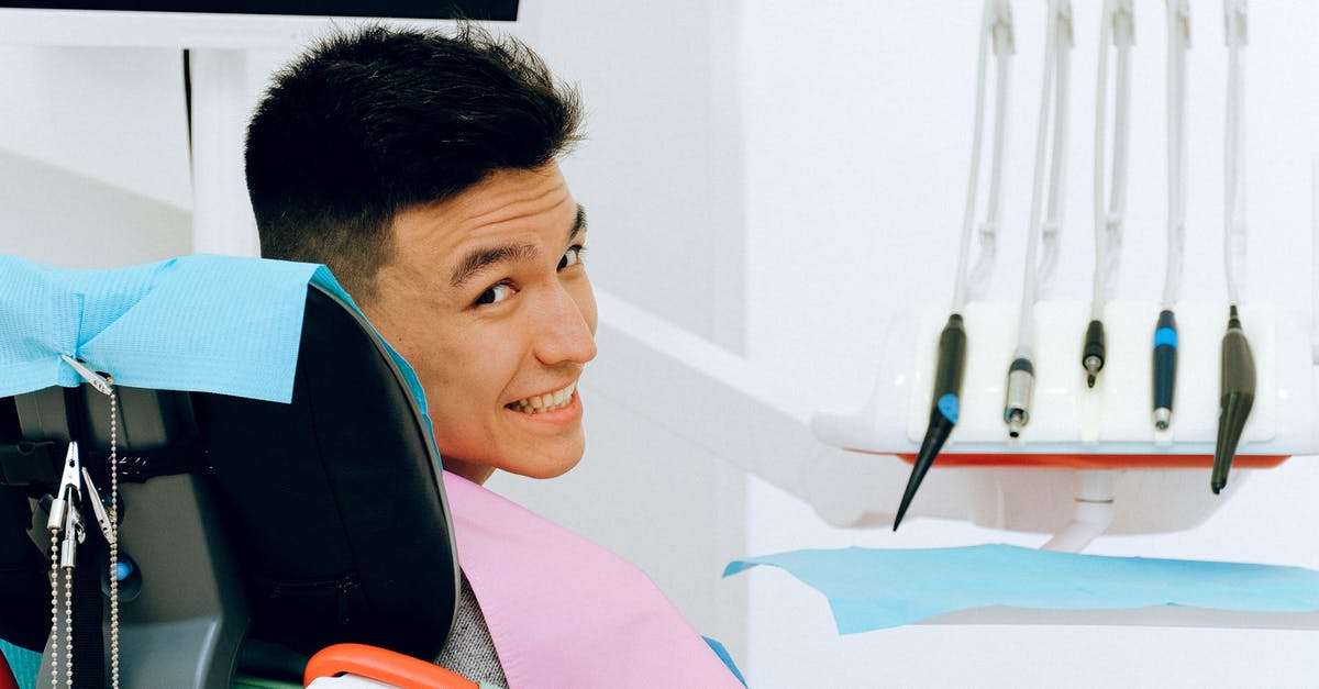 Faster to wet cure in room temp? - Back view of smiling ethnic man sitting in chair of dentist while preparing for treatment in modern clinic and looking over shoulder at camera Faster to wet cure in room temp? - Back view of smiling ethnic man sitting in chair of dentist while preparing for treatment in modern clinic and looking over shoulder at camera