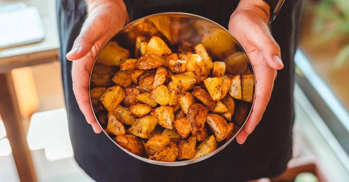 Fastest way to cook a baked potato? - From above of crop anonymous male chef in apron standing with bowl of potato wedges Fastest way to cook a baked potato? - From above of crop anonymous male chef in apron standing with bowl of potato wedges