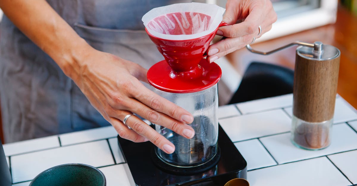 Filtering home-rendered lard - Woman barista preparing fresh alternative coffee in cafe Filtering home-rendered lard - Woman barista preparing fresh alternative coffee in cafe
