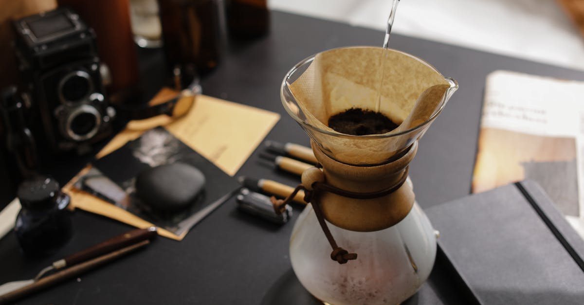 Filtering home-rendered lard - Person Pouring Liquid in a Clear Glass with Coffee Filter Filtering home-rendered lard - Person Pouring Liquid in a Clear Glass with Coffee Filter