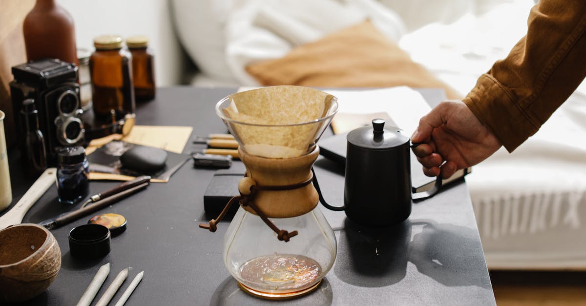Filtering home-rendered lard - Person Holding Black Coffee Pot near a Clear Glass Filtering home-rendered lard - Person Holding Black Coffee Pot near a Clear Glass