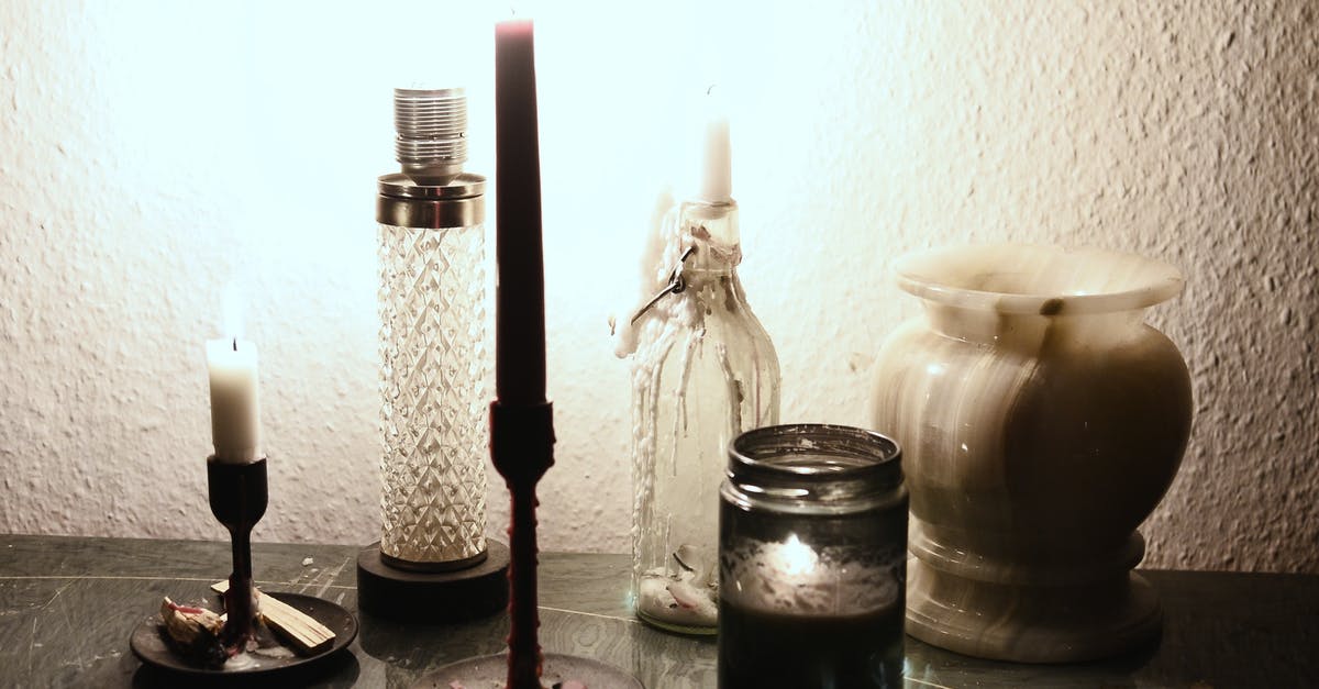 Fire under electric stovetop element - Glowing lamp illuminating dark room placed on table near burning candles on candlesticks and empty ceramic vase Fire under electric stovetop element - Glowing lamp illuminating dark room placed on table near burning candles on candlesticks and empty ceramic vase