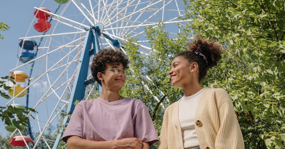 First slicing, then cooking, or the other way around? - Teenagers standing under ferris wheel and looking at each other with smile First slicing, then cooking, or the other way around? - Teenagers standing under ferris wheel and looking at each other with smile
