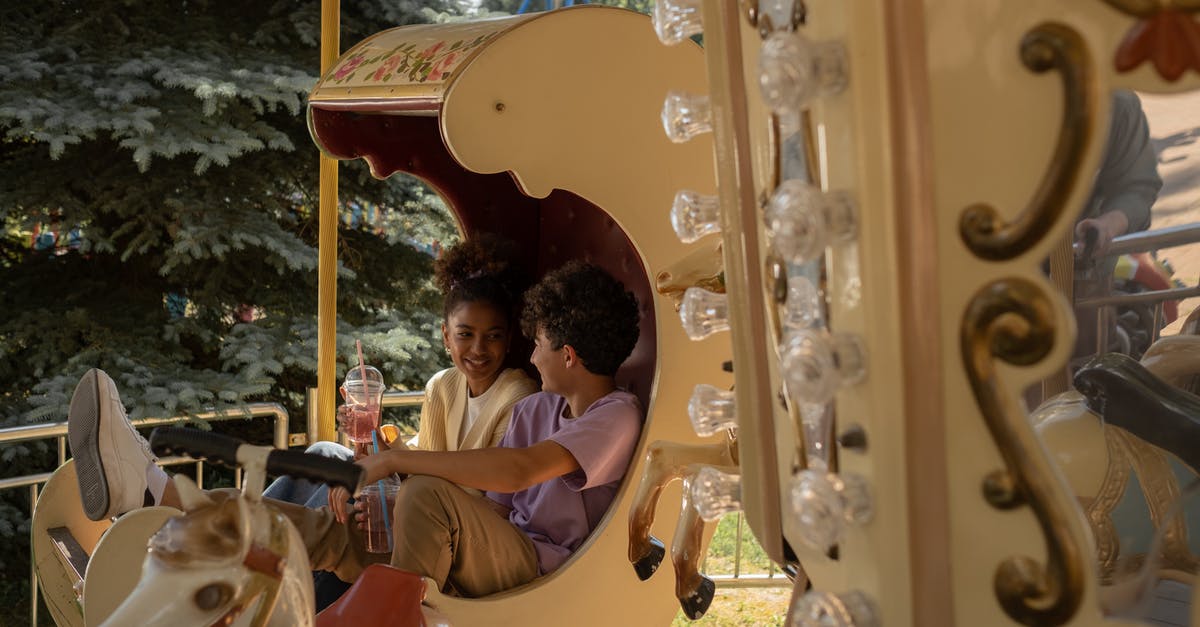 First slicing, then cooking, or the other way around? - Teenage couple sitting in carousel seat smiling and talking to each other First slicing, then cooking, or the other way around? - Teenage couple sitting in carousel seat smiling and talking to each other