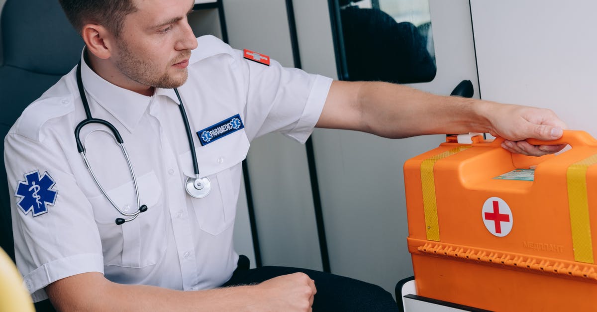 First-Aid Kit for Kitchens - A Man Sitting while Holding a First Aid Kit First-Aid Kit for Kitchens - A Man Sitting while Holding a First Aid Kit