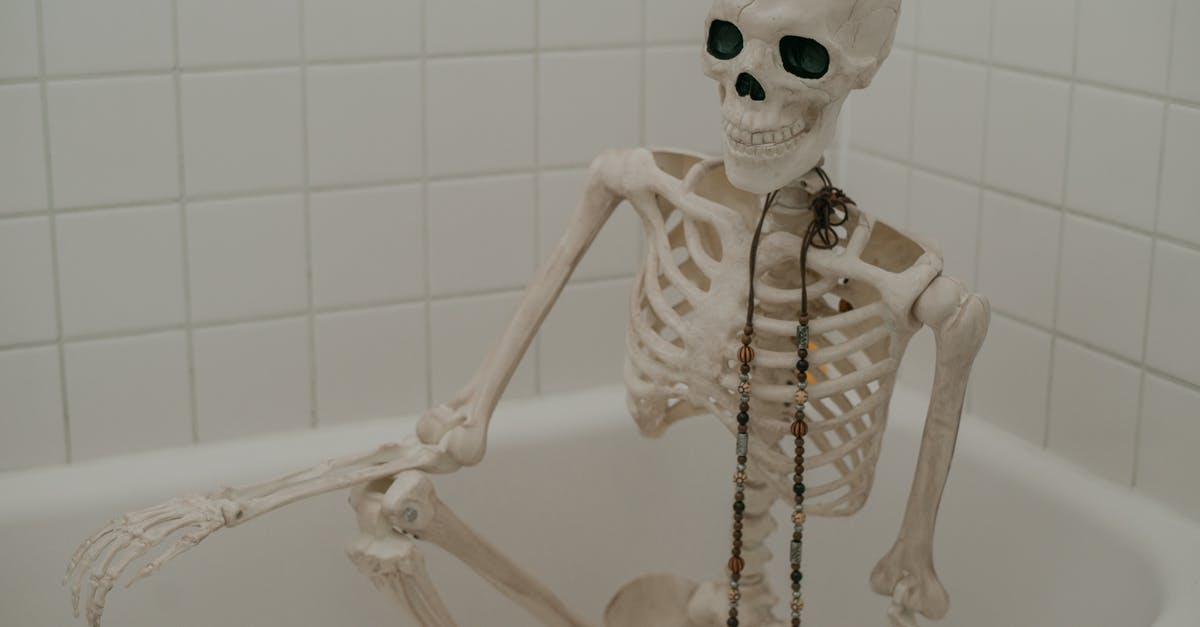 Fish bone broth separating after long long boil - White skeleton with long chaplet sitting in bath without water in bathroom with white tiles on wall Fish bone broth separating after long long boil - White skeleton with long chaplet sitting in bath without water in bathroom with white tiles on wall