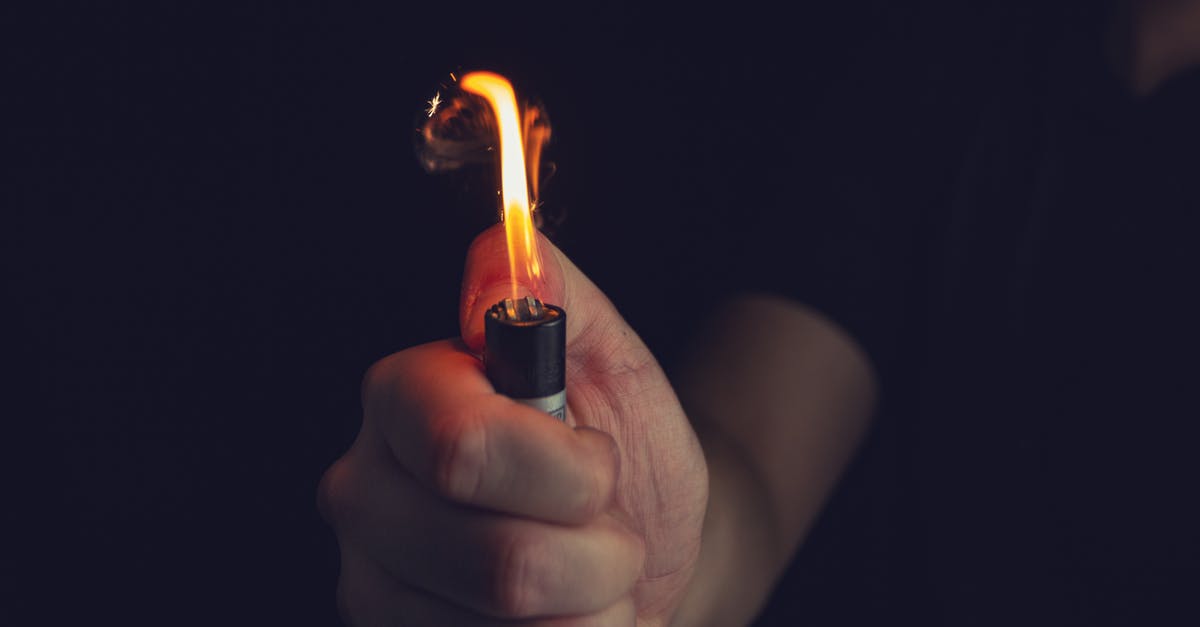 Flammable gas emitted by sausage - Crop unrecognizable man firing lighter in darkness Flammable gas emitted by sausage - Crop unrecognizable man firing lighter in darkness