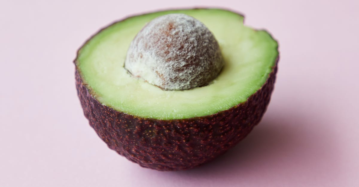 Flavor in avocadoes gone forever? - High angle of half of fresh ripe avocado with seed on purple background Flavor in avocadoes gone forever? - High angle of half of fresh ripe avocado with seed on purple background