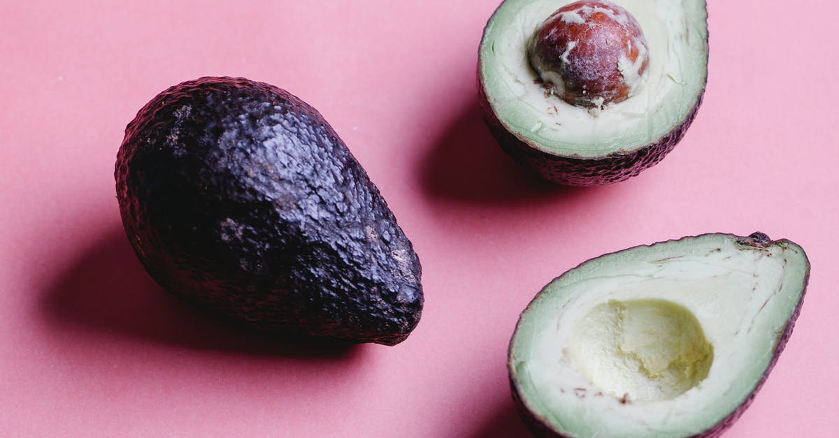 Flavor in avocadoes gone forever? - Composition of halved avocados on pink background Flavor in avocadoes gone forever? - Composition of halved avocados on pink background