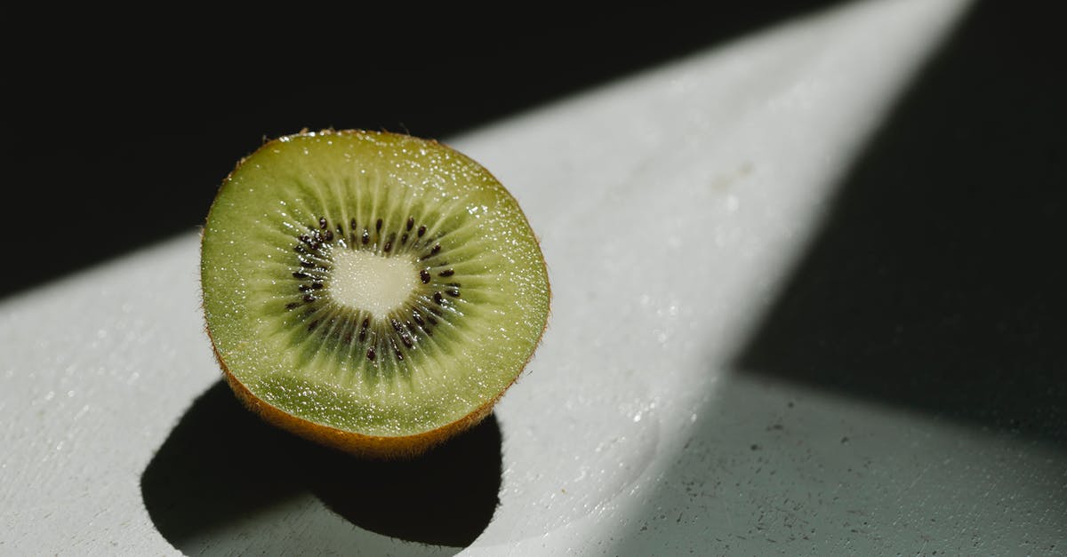Food is still undercooked on cast iron - Half of fresh juicy kiwi at sunshine Food is still undercooked on cast iron - Half of fresh juicy kiwi at sunshine