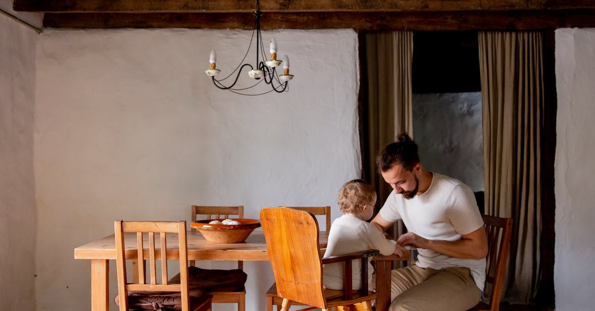 Forgot to feed my 6-day old sourdough starter yesterday, can I just carry on today? - Focused young man with toddler girl sitting at desk in rural interior house