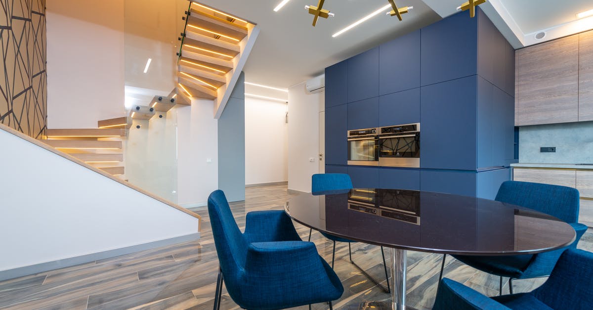 Fork left in microwave, hole in microwave wall - Modern dining room interior with furniture against staircase at home Fork left in microwave, hole in microwave wall - Modern dining room interior with furniture against staircase at home