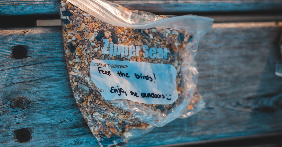 Found a kind of worm in my rice bag, what should I do? [duplicate] - From above of transparent plastic zipper bag with bird feed and titles on wooden plank