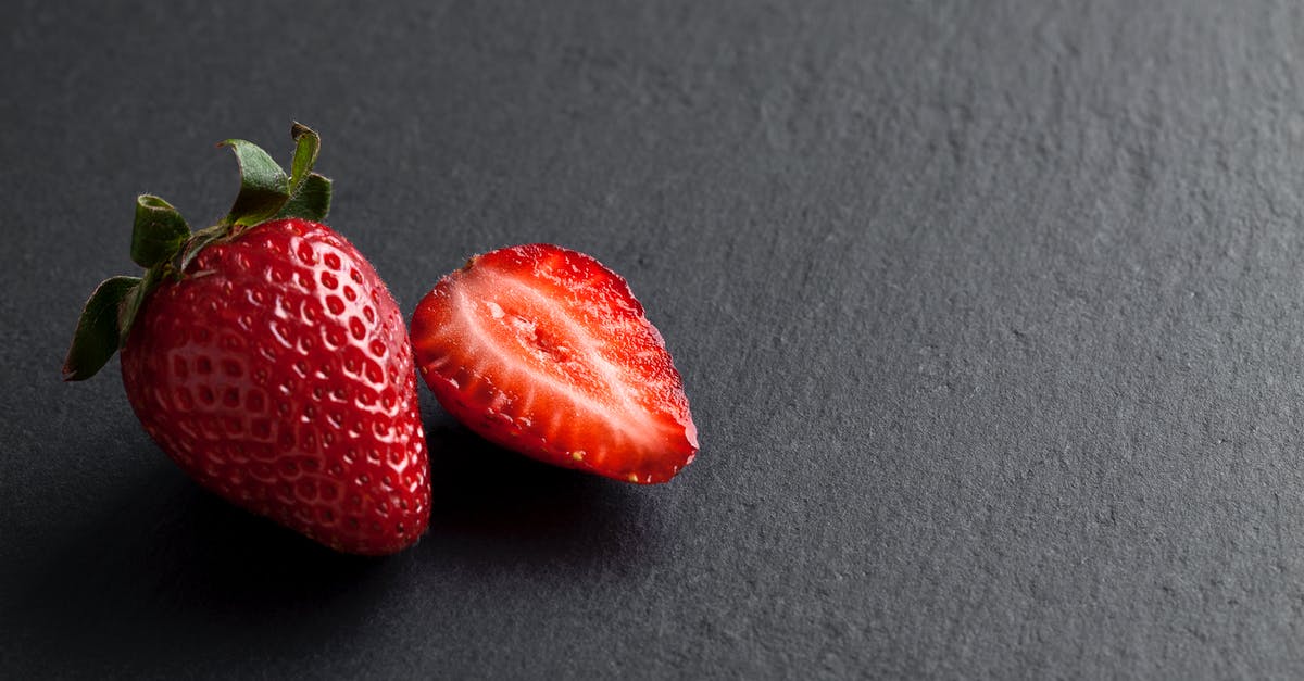 Freezing whole strawberries - A Whole and Sliced Strawberries on Grey Background Freezing whole strawberries - A Whole and Sliced Strawberries on Grey Background