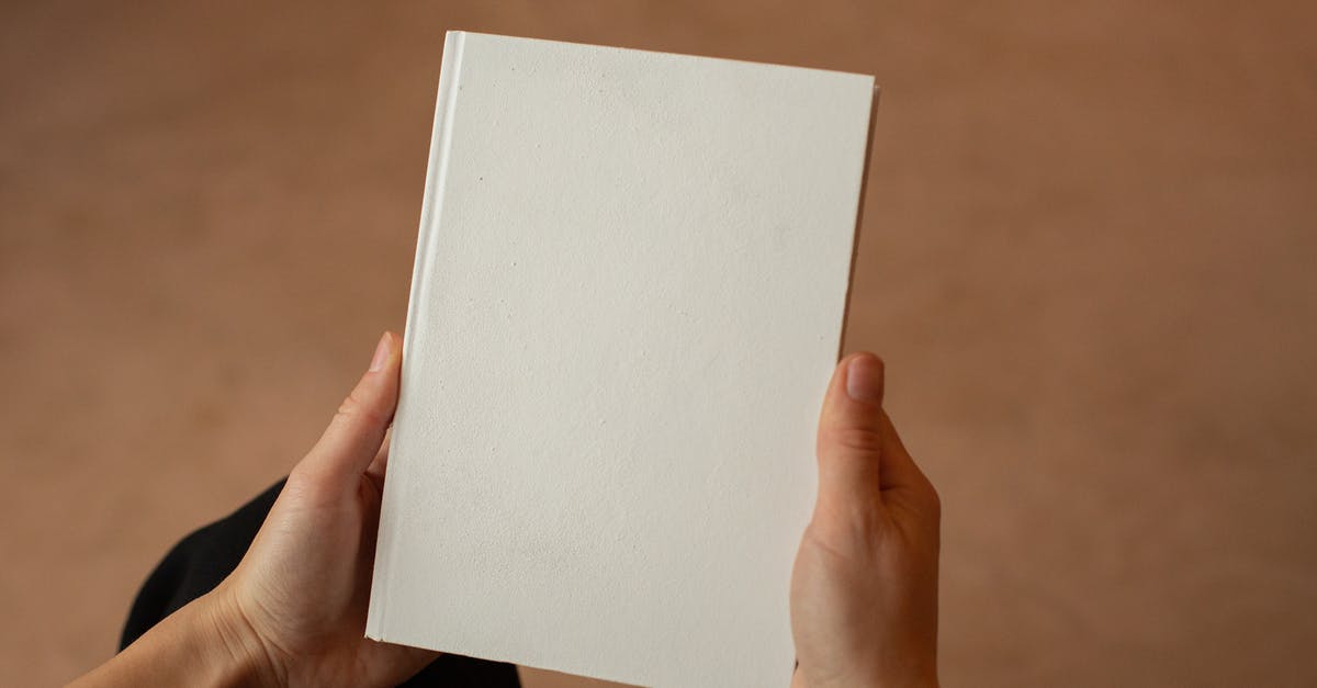French (?) pastry on the cover of a book - Person holding hardcover book with blank cover French (?) pastry on the cover of a book - Person holding hardcover book with blank cover