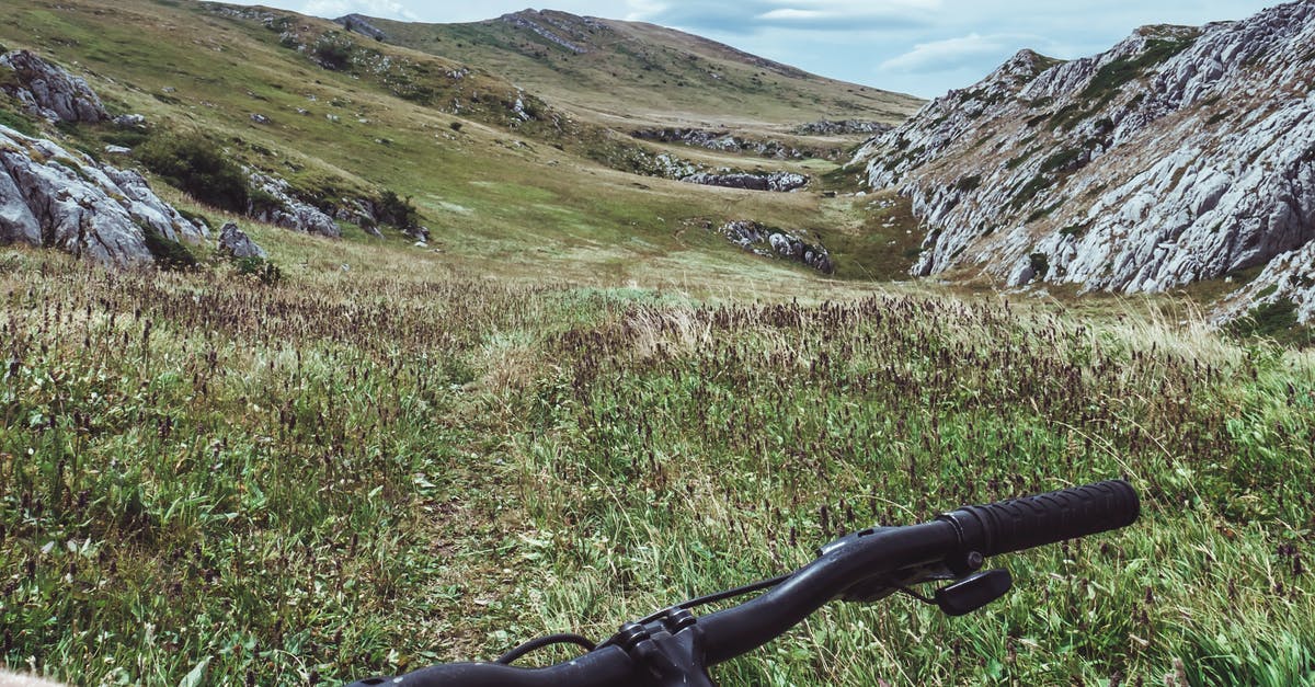 French whisk handle has rocks in it? - Person Riding Bicycle Overlooking Green Grass Field and Hill French whisk handle has rocks in it? - Person Riding Bicycle Overlooking Green Grass Field and Hill
