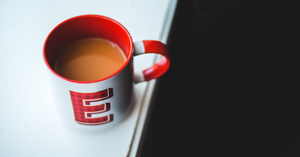 Fresh milk curdles when added to hot coffee and tea - Cup of coffee with milk on white table Fresh milk curdles when added to hot coffee and tea - Cup of coffee with milk on white table