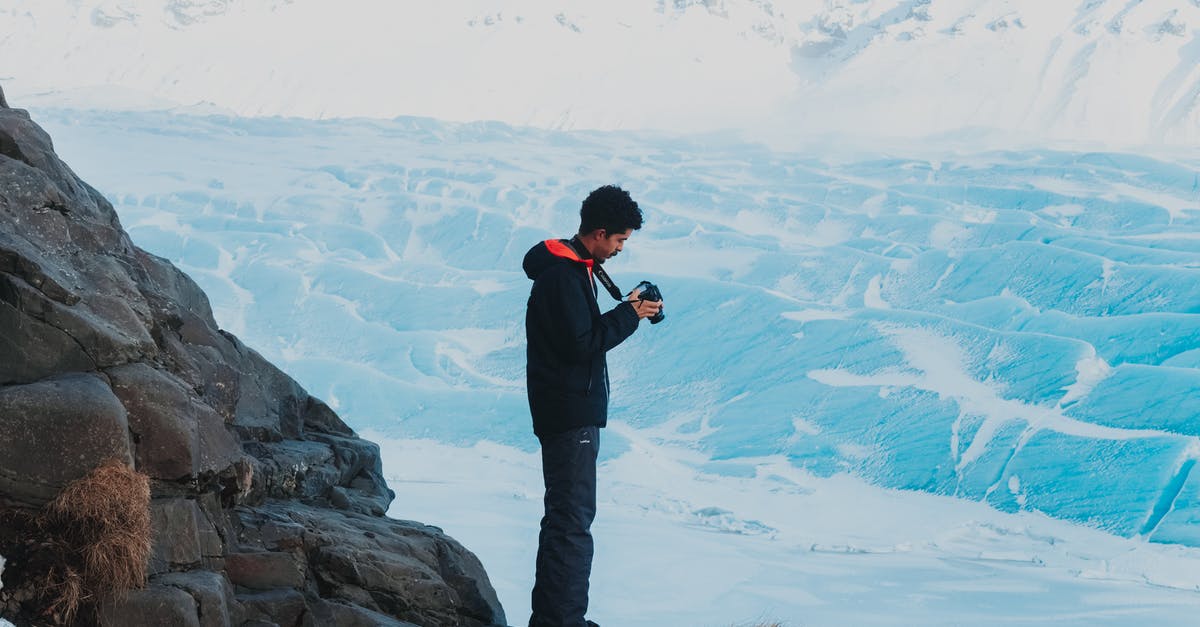 frozen chips always take longer - Man with camera in hands in winter mountains frozen chips always take longer - Man with camera in hands in winter mountains