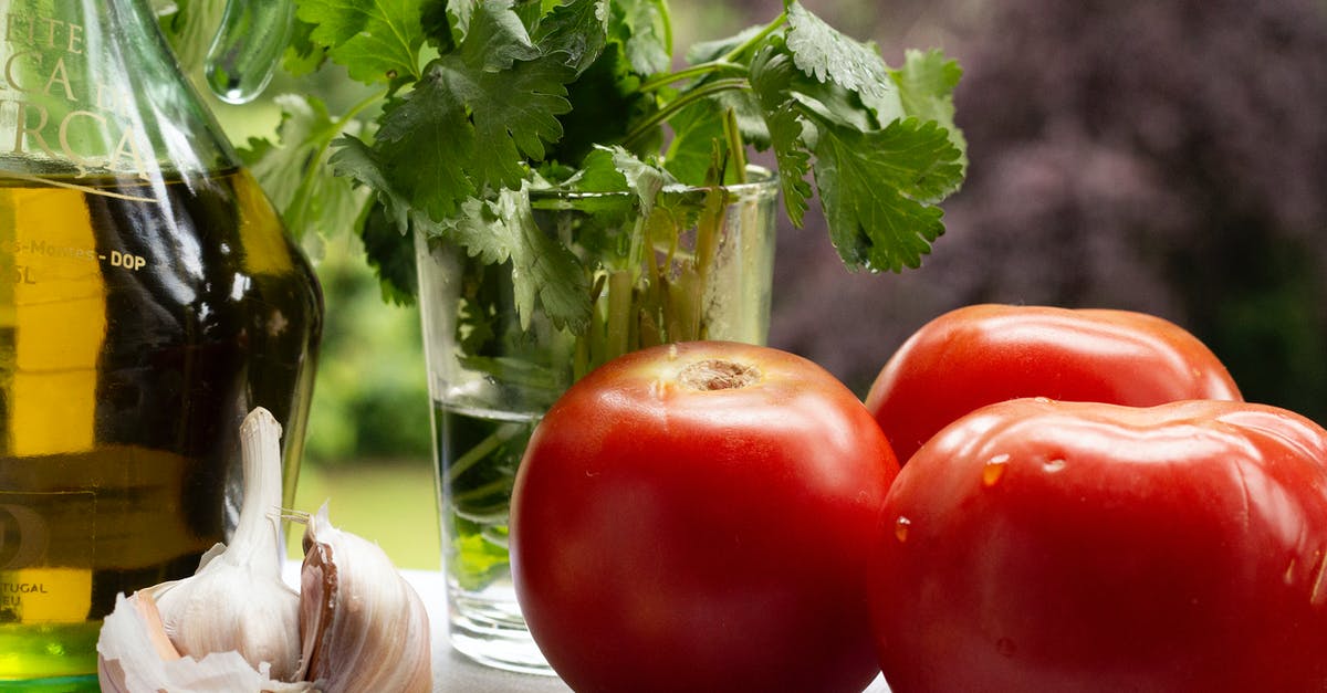 Garlic and oil emulsion - Tomatoes with garlic cloves near fresh parsley and oil Garlic and oil emulsion - Tomatoes with garlic cloves near fresh parsley and oil