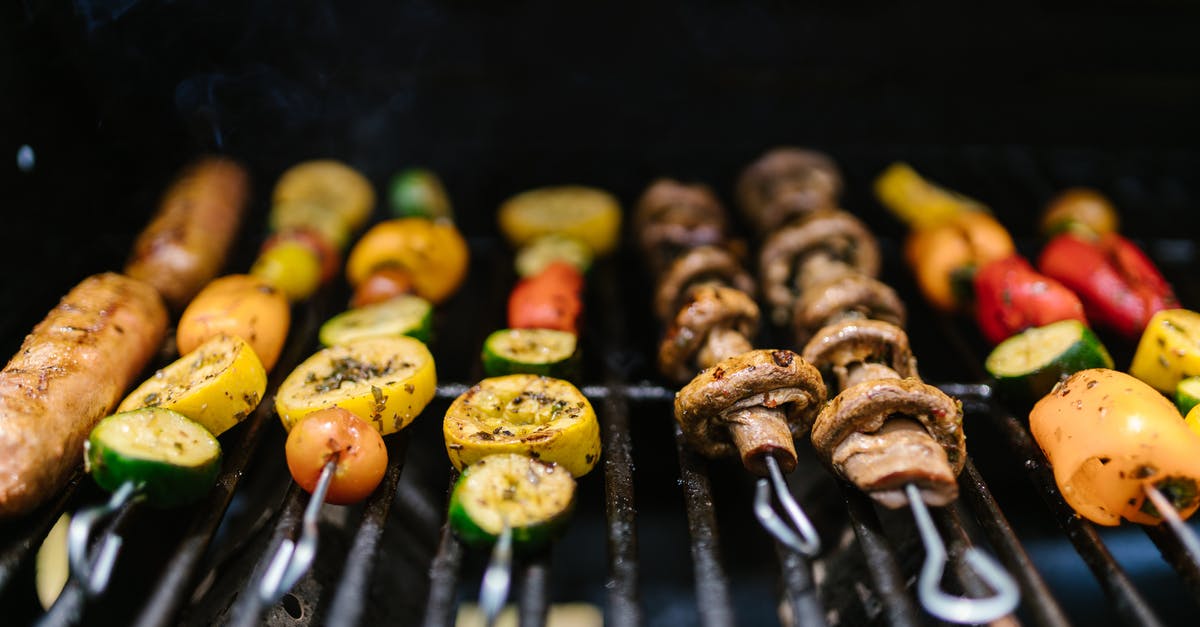Gas grill flames very high cooking chicked wings and vegetables - A Vegetables Cooking in the Griller Gas grill flames very high cooking chicked wings and vegetables - A Vegetables Cooking in the Griller