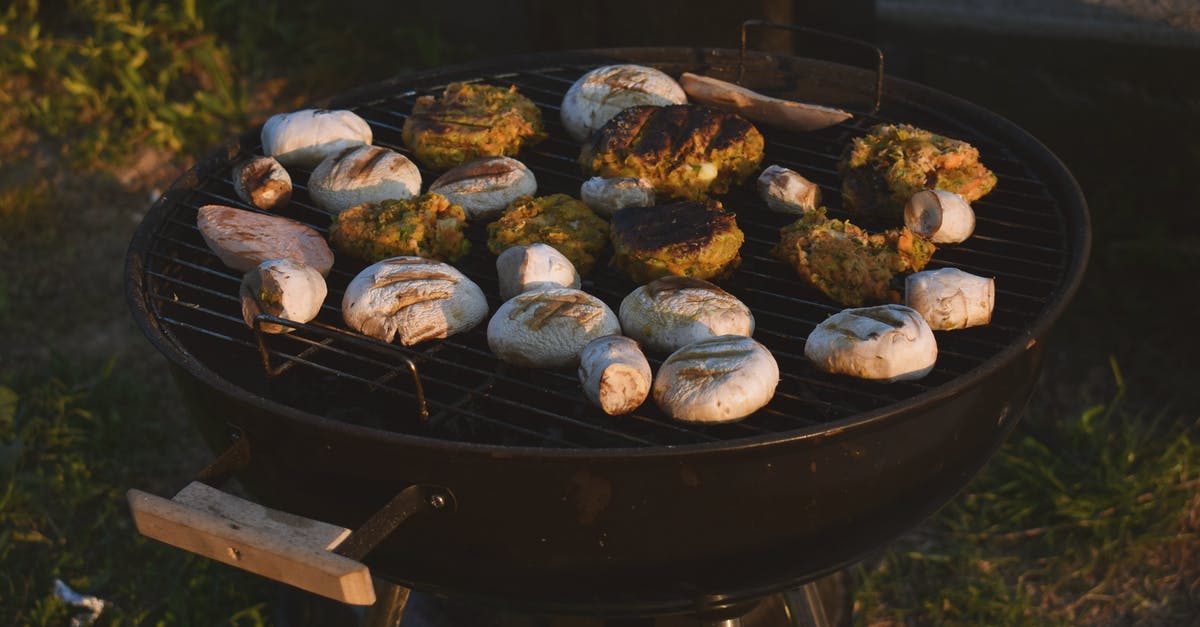 Gas grill flames very high cooking chicked wings and vegetables - Assorted Grilled Food on Black Grill Gas grill flames very high cooking chicked wings and vegetables - Assorted Grilled Food on Black Grill
