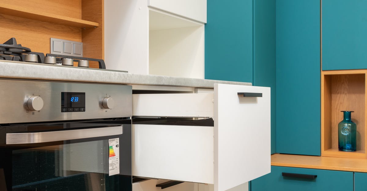 Gas or electric for rack oven in a bakery? - Open drawer of cabinet against oven in modern kitchen Gas or electric for rack oven in a bakery? - Open drawer of cabinet against oven in modern kitchen