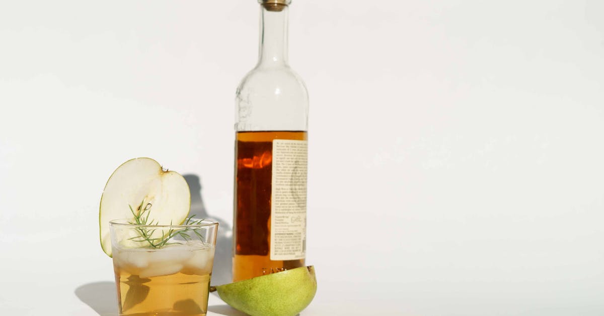 Getting rid of a commercial/plastic taste in icing? - Glass bottle of calvados with halved pear and rosemary sprigs placed on white background Getting rid of a commercial/plastic taste in icing? - Glass bottle of calvados with halved pear and rosemary sprigs placed on white background