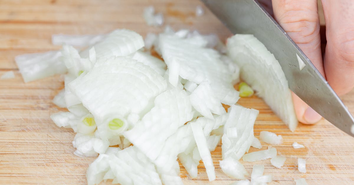 Getting rid of raw onion taste without the frying process? - Chef slicing ripe onion on wooden cutting board Getting rid of raw onion taste without the frying process? - Chef slicing ripe onion on wooden cutting board