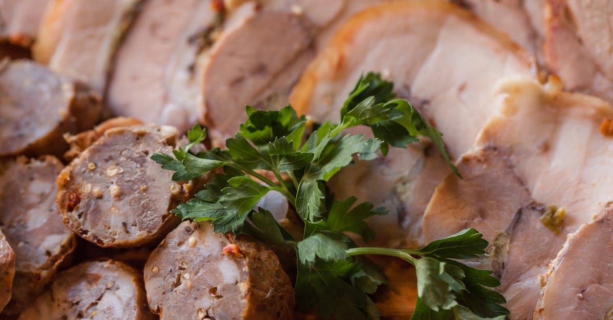 Given that fat has a lower specific heat than water, why do meats with higher fat content take longer to cook? - From above of tasty sliced sausage and meat placed on plate in daytime