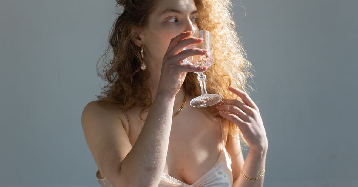 Glass drink dispenser for vinegar long term storage? - Young female with curly hair bare shoulders and chest looking away while drinking water on white background Glass drink dispenser for vinegar long term storage? - Young female with curly hair bare shoulders and chest looking away while drinking water on white background