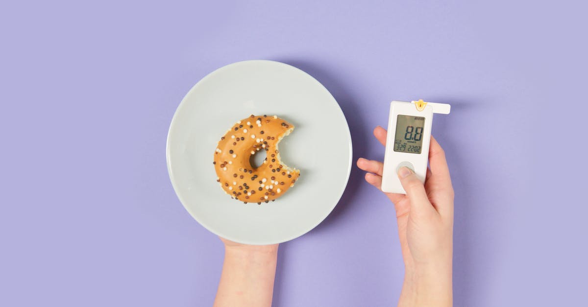 Glucose in sweet bread? - Person Holding a Glucometer and a Plate with a Donut Glucose in sweet bread? - Person Holding a Glucometer and a Plate with a Donut