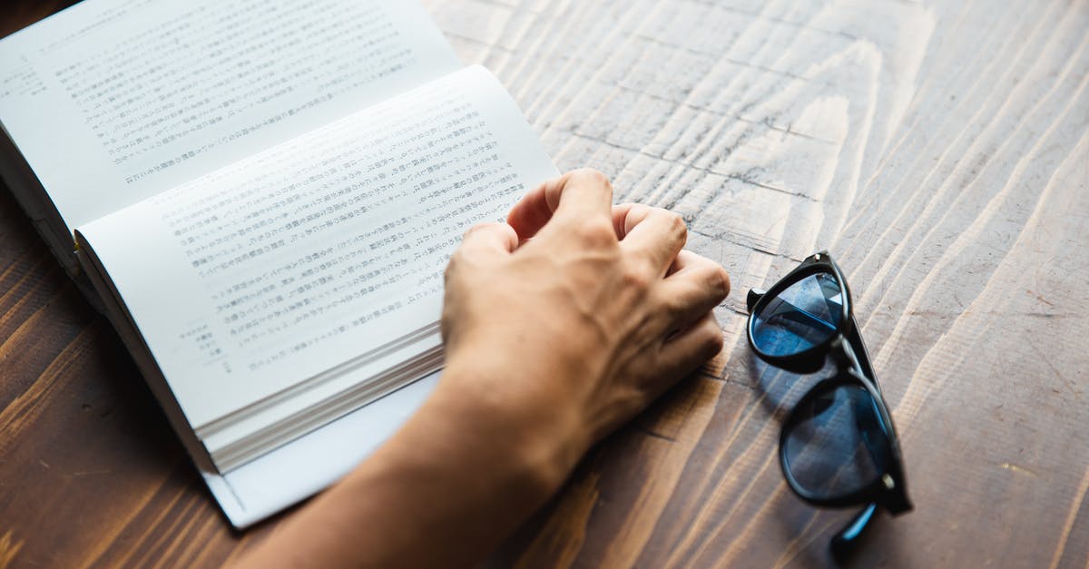 Good book on the chemistry of cooking? - Crop faceless person sitting at table and reading book Good book on the chemistry of cooking? - Crop faceless person sitting at table and reading book
