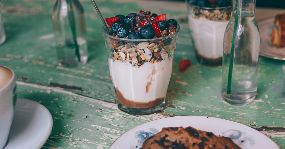 Granola - how to reduce sugar - Portions of appetizing sweet dessert with oatmeal and berries in glasses on shabby wooden table Granola - how to reduce sugar - Portions of appetizing sweet dessert with oatmeal and berries in glasses on shabby wooden table