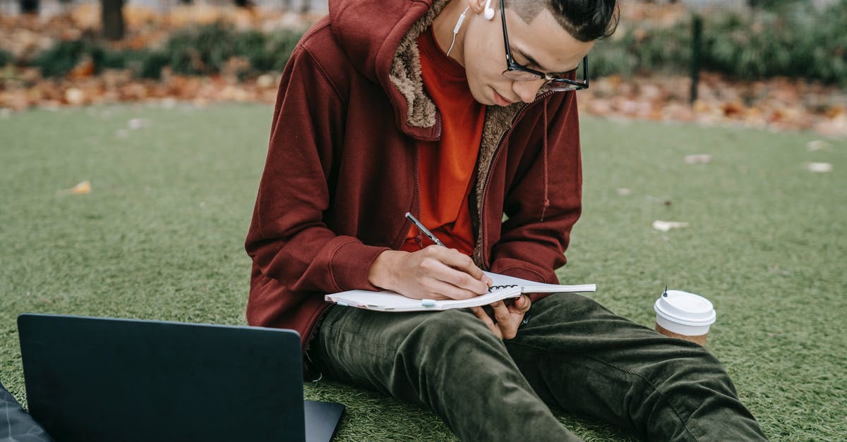Grassy Tea and brands - Man studying with notepad and laptop on grassy lawn Grassy Tea and brands - Man studying with notepad and laptop on grassy lawn