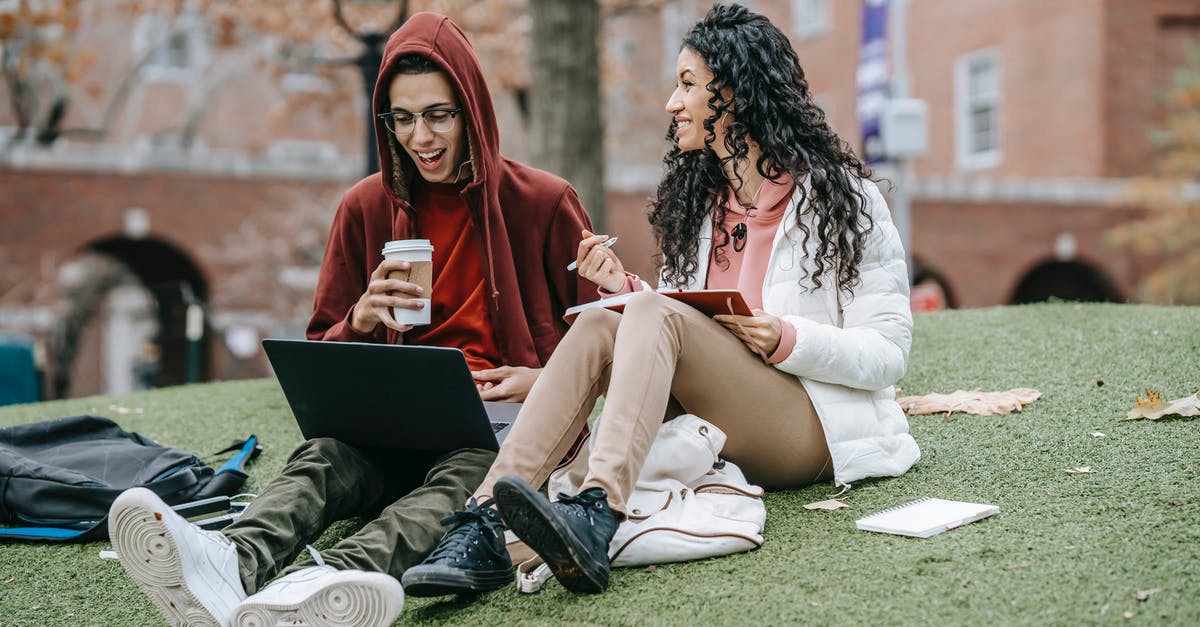 Grassy Tea and brands - Multiethnic friends studying with notepad and netbook on grassy field Grassy Tea and brands - Multiethnic friends studying with notepad and netbook on grassy field