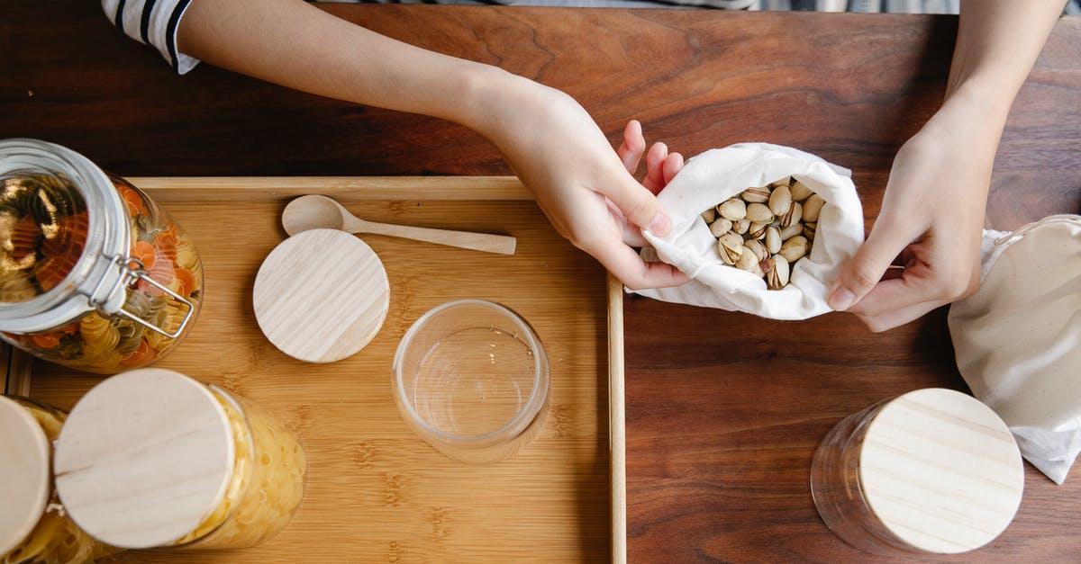 Green and white mold on dry part of onion only. What to do? - Crop person with bag of pistachios on table Green and white mold on dry part of onion only. What to do? - Crop person with bag of pistachios on table