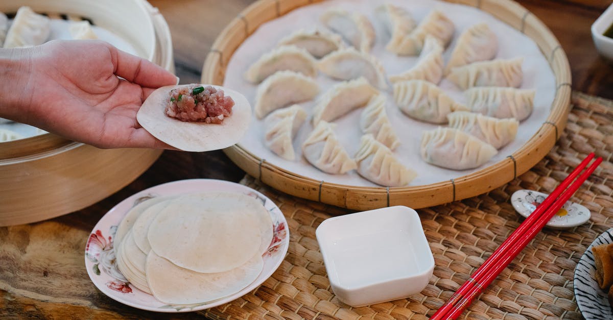 Ground beef storage and use past sell-by date - From above of crop anonymous female demonstrating dough circle with minced meat filling above table with dumplings at home Ground beef storage and use past sell-by date - From above of crop anonymous female demonstrating dough circle with minced meat filling above table with dumplings at home