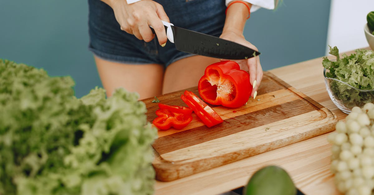 Gyuto knife - What it can & can't cut? What cutting techniques? - Person Holding Knife Slicing Red Tomato Gyuto knife - What it can & can't cut? What cutting techniques? - Person Holding Knife Slicing Red Tomato