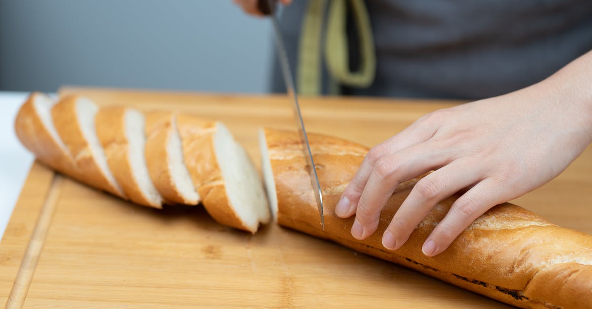 Gyuto knife - What it can & can't cut? What cutting techniques? - Person Slicing Bread on Brown Wooden Chopping Board Gyuto knife - What it can & can't cut? What cutting techniques? - Person Slicing Bread on Brown Wooden Chopping Board