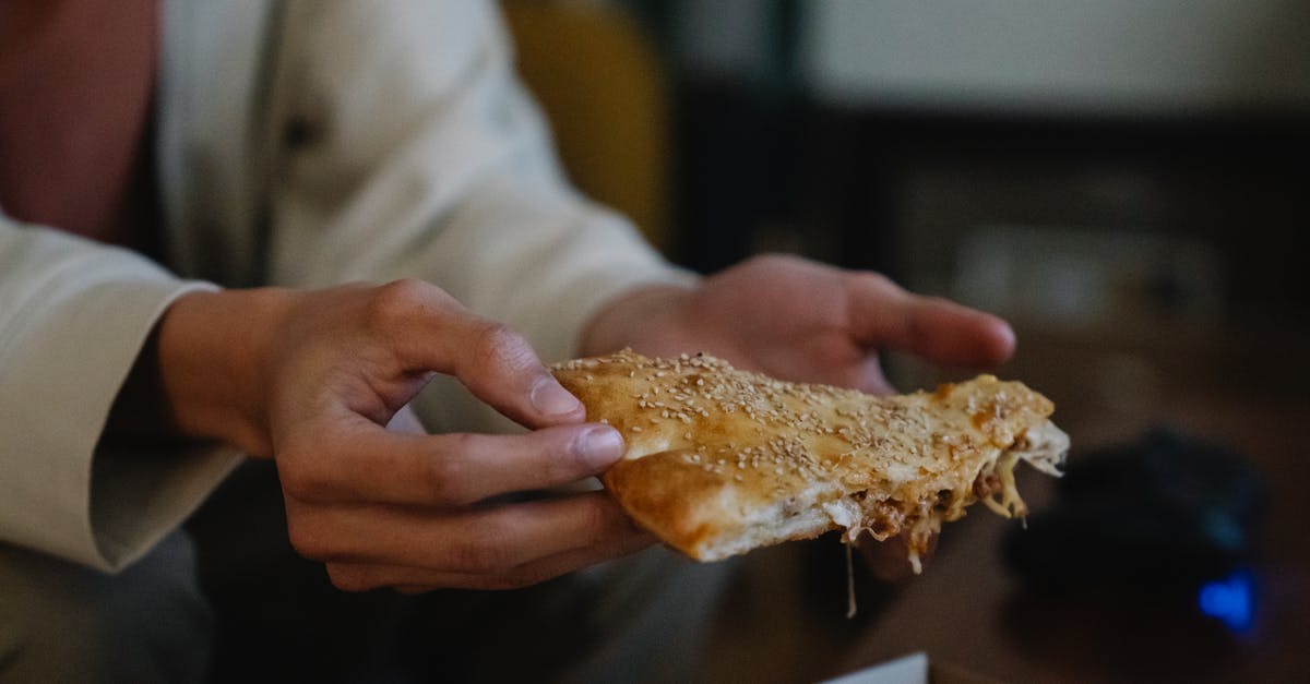 having problem with chicken pot pie crust - Crop unrecognizable male with tasty pie piece with sesame seeds on top in house room having problem with chicken pot pie crust - Crop unrecognizable male with tasty pie piece with sesame seeds on top in house room