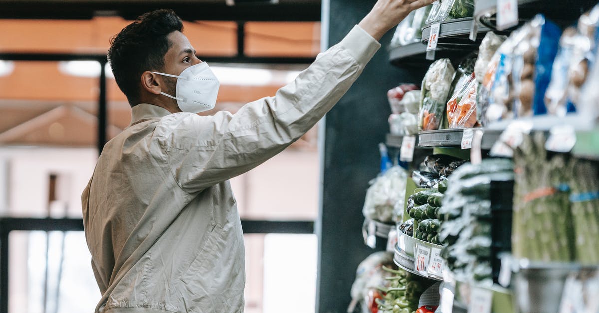 Health department food safety - Indian man choosing groceries in supermarket