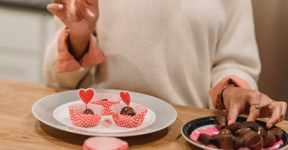Heart shaped mold - Unrecognizable female serving sweet chocolate candies into molds on plate decorated with red hearts while standing near table in kitchen at home Heart shaped mold - Unrecognizable female serving sweet chocolate candies into molds on plate decorated with red hearts while standing near table in kitchen at home