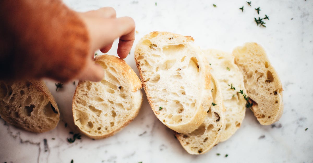 Heating part baked baguettes in lid-covered pyrex - Slices of bread on table Heating part baked baguettes in lid-covered pyrex - Slices of bread on table