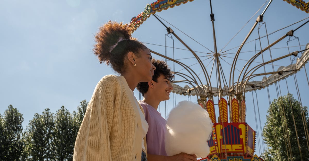 Help making cotton candy - clumps and is wet? - Teenage couple walking by big carousel and boy holding cotton candy