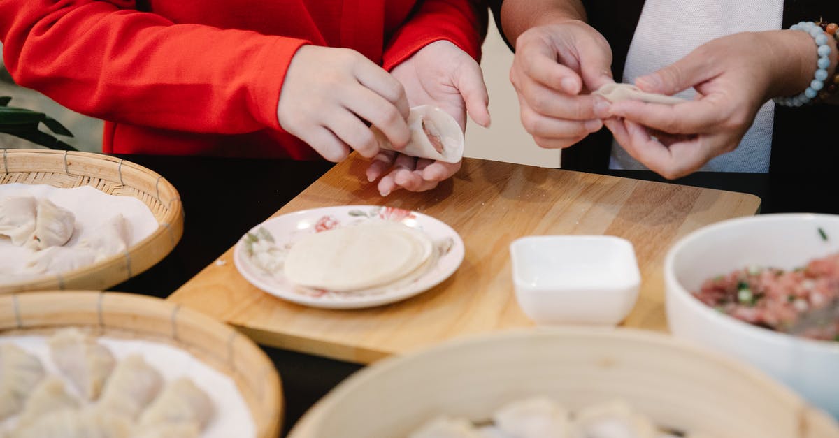 Help wanted to identify this food item (oriental) - Crop anonymous teen girl making traditional Chinese jiaozi dumplings while cooking lunch together at table with ingredients and bamboo steamer Help wanted to identify this food item (oriental) - Crop anonymous teen girl making traditional Chinese jiaozi dumplings while cooking lunch together at table with ingredients and bamboo steamer