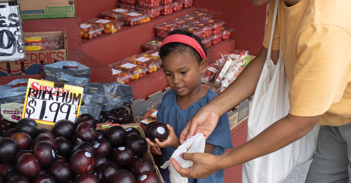 Help with friend with many allergies - Ethnic girl choosing fruit in market with mother Help with friend with many allergies - Ethnic girl choosing fruit in market with mother